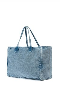 Sac en denim bleu clair, de forme rectangulaire, avec deux poignées robustes et des accents de couture visibles le long des bords.