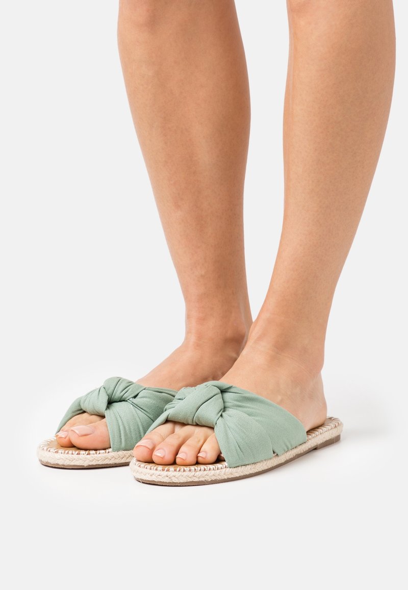 Gröna knutna tygsandaler med en vävd jute-sula, öppen tån och mjuk textur för komfort.
