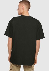 Zwarte t-shirt met korte mouwen, gemaakt van zacht katoen, met een relaxed fit en ronde hals, en een eenvoudige achterkant.