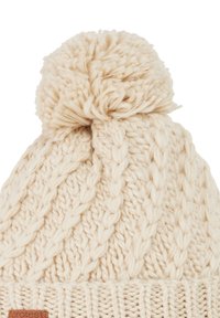 Knitted cream-colored beanie with a pom-pom on top, featuring a cable pattern and a ribbed cuff at the base. Leather tag on the cuff.