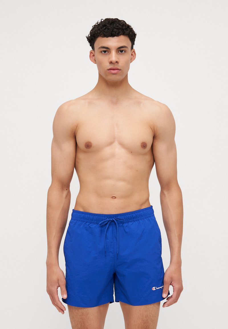 Shorts de bain bleus en tissu léger, avec une taille élastique à cordon de serrage et un petit logo accentué sur l'ourlet.