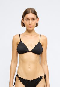 Μαύρο σετ μπικίνι με λοξές άκρες, λεπτές ρυθμιζόμενες τιράντες και κάτω μέρος με κορδόνι στο πλάι. Φτιαγμένο από λεία, ελαστική ύφανση.