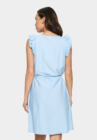 Rochie bleu deschis cu umeri volan, talie strânsă și tiv evazat. Fabricată dintr-un material moale, cu o textură subtilă.