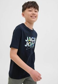 Mornarska pamučna majica s višebojnim grafičkim prikazom "JACK & JONES", okrugli izrez, kratki rukavi i opušteni kroj. Minimalistički dizajn na običnoj pozadini.
