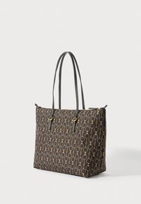 Saco tote preto com padrão de corrente de círculos ligados em beje e finas alças de ombro em couro preto, em pé contra um fundo branco.