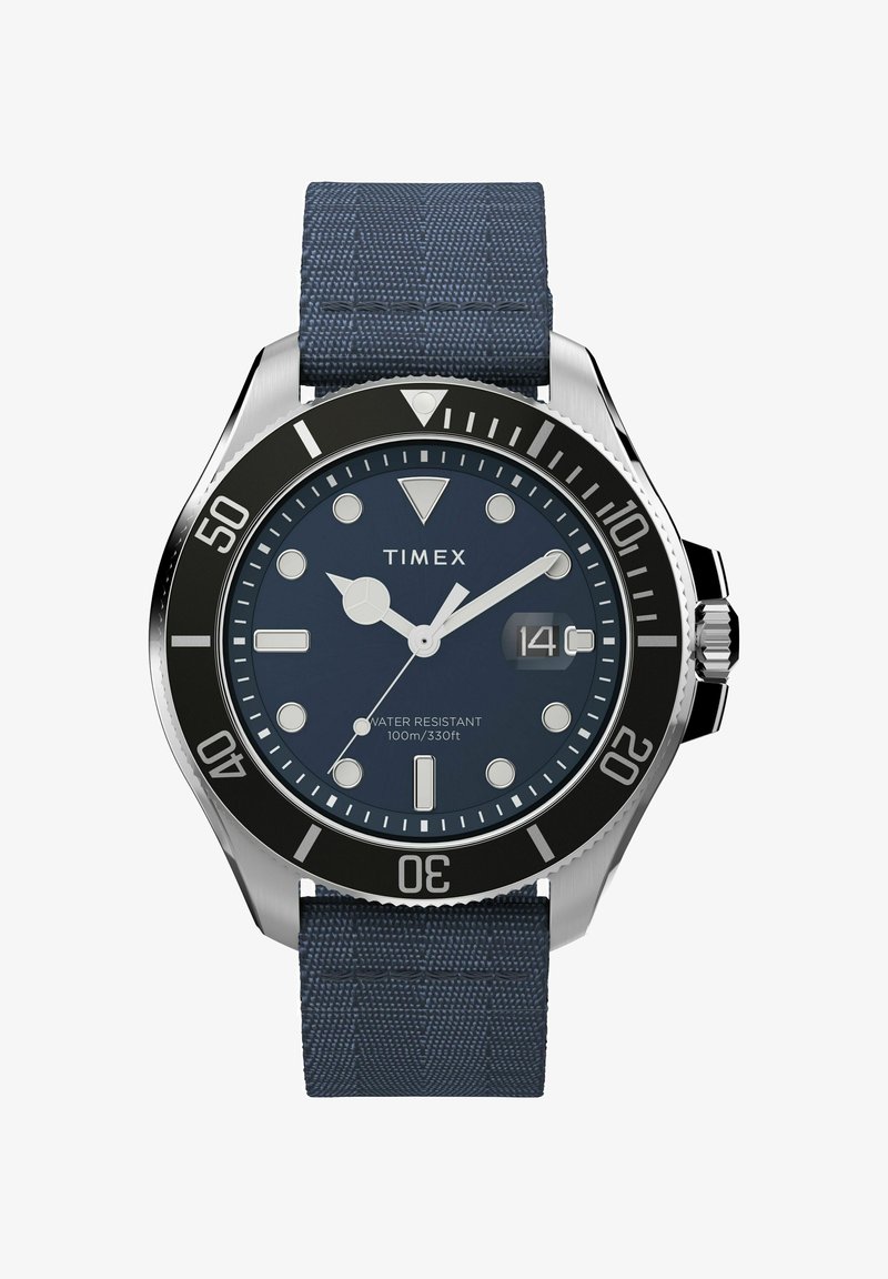 Zegarek Timex z kopertą ze stali nierdzewnej, granatowym paskiem z tkaniny, czarną lunetą i okrągłą niebieską tarczą. Wodoszczelny do 100 m/330 stóp.