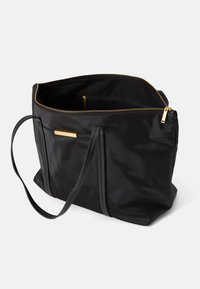 Saco tote em nylon preto com fecho e detalhes dourados. Possui duas alças longas, um interior espaçoso e um bolso exterior com uma placa dourada.