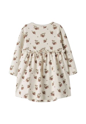 Robe crème à manches longues pour enfant avec taille froncée, recouverte d’un motif répété de fruits bruns et de feuilles vertes.
