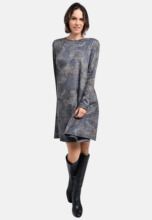 Langärmliges, knielanges Kleid aus strukturierter grauer Stoff mit Blumendesign. Kombiniert mit hohen schwarzen Lederstiefeln.