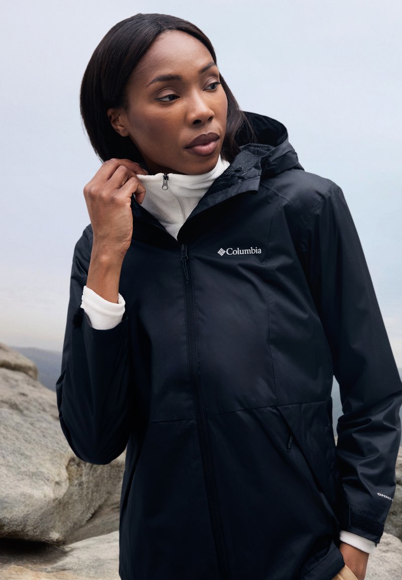 Black waterproof jacket with a hood, zippered front, and angled pockets. The fabric has a smooth texture, featuring a small logo on the chest.