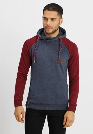 Pullover sweatshirt med blåt krop og bordeauxfarvede ærmer. Har cowl neck, snoretræk og brune læderdetaljer. Glat tekstur.