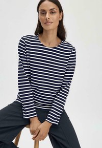 Marineblau und weiße gestreifte Langarmbluse mit Rundhalskragen, in lockerer Passform und aus weichem Baumwollmaterial. Lässiges Design, minimalistischem Stil.