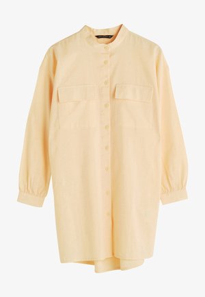 Lange mouwen, lichtgele blouse met knoopsluiting, opstaande kraag en twee borstzakken met klep, voorzien van geplooide manchetten en een comfortabele pasvorm.