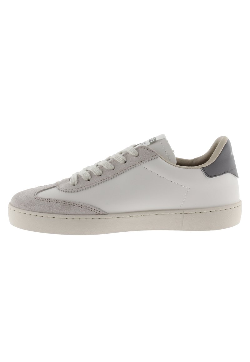 Sneaker bianco con dettagli in suede grigio, punta rotonda, superficie texture e lacci piatti. I pannelli laterali sono in pelle liscia e presentano un branding minimale.