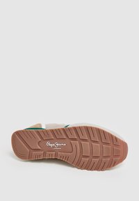 Sneaker con tomaia in tessuto beige, dettagli verdi e suola in gomma testurizzata. Logo stampato sul lato e motivo della suola distintivo.