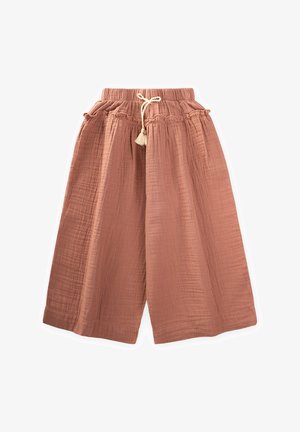 Pantalones anchos de color óxido, hechos de una tela texturizada, con una cinturilla elástica con cordón y borlas decorativas.