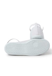 Scarpe bianche in tela con suola in gomma texturizzata, caratterizzate da un design minimalista e cinturini regolabili sul retro.