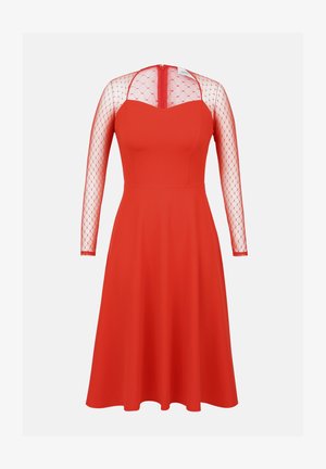 Robe rouge avec un buste ajusté et une jupe évasée. Comprend des manches longues en tulle transparent et une fermeture éclair dans le dos. Texture de tissu lisse.
