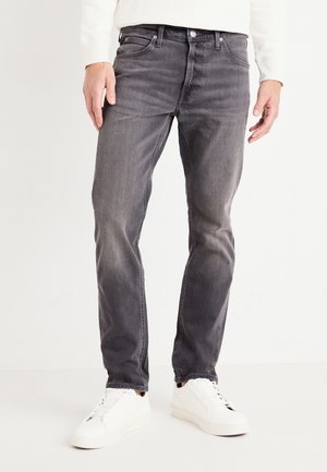 Mörkgrå jeans i denim med subtil blekning. Slim fit, femfickorsdesign och standard knappstängning. Bärs med vita sneakers.
