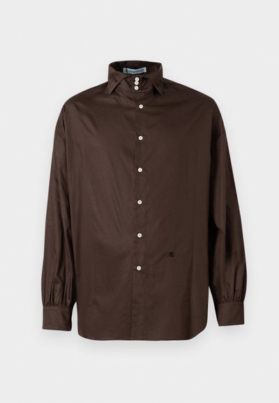 Camisa de manga longa castanha em tecido suave, com colarinho clássico, fecho de botões na frente e punhos elásticos; apresenta um detalhe de logotipo discreto.
