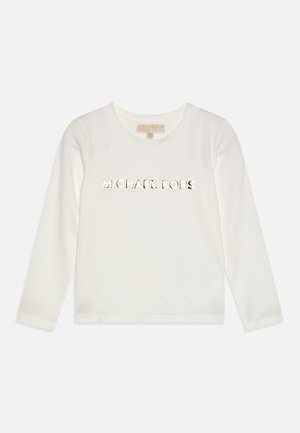 Biała koszulka z długim rękawem i okrągłym dekoltem z metalicznym napisem „MICHAEL KORS” na środku klatki piersiowej, prezentowana na jednolitym tle.