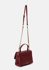 Sac à main matelassé bordeaux avec une forme structurée, une anse haute et une bandoulière agrémentée de chaînes. Détails en métal doré.