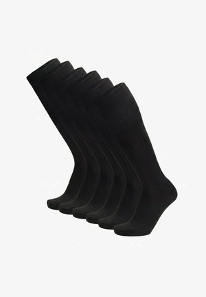 Sechs Paare schwarze, halbhohe, gerippte Socken, aufrecht vor einem weißen Hintergrund angeordnet.