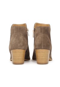 Botine din suede, de culoare maro deschis, cu bot rotund, fermoare laterale și un toc compus din lemn, în dungi. Căptușeală interioară netedă.