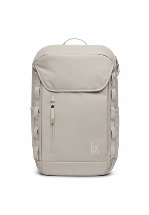Sac à dos en tissu gris avec une poche avant zippée, des sangles latérales et une poignée sur le dessus. Présente le logo "GOT BAG" sur le bas à l'avant.
