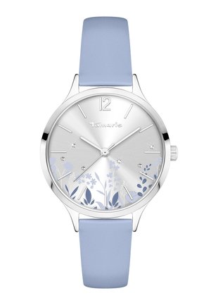 Silberne runde Uhr mit hellblauem Lederarmband, floralen Designs auf dem Zifferblatt, Kristall-Stundenmarkierungen und dem "Tamaris"-Logo unterhalb der 12-Uhr-Position.