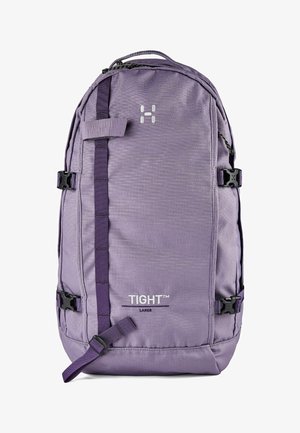Grand sac à dos TIGHT™ violet avec sangle verticale à l'avant, boucles latérales réglables et poignée supérieure.