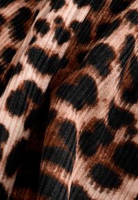 Material cu imprimeu leopard, ce prezintă tonuri de maro, negru și bej, într-o textură ribbed. Patternul include pete de dimensiuni variate și o apariție moale.