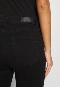 Zwarte spijkerbroek van denim met een strakke pasvorm, voorzien van een leren LTB-label, achterzakken en subtiele stiksels langs de naden.