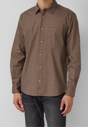 Brązowa koszula na długi rękaw z małym ciemnym geometrycznym wzorem, zapinana na guziki, noszona z ciemnoszarymi dżinsami na stojącej osobie.