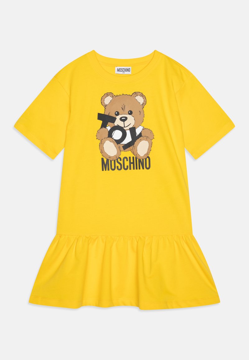 Žuta pamučna haljina s volanima na rubu i grafikom medvjedića s tekstom "Toy Moschino". Kratki rukavi i okrugli izrez.