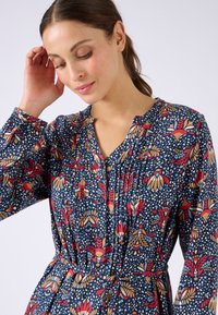 Abito floreale navy con motivi rossi e gialli, patta dei bottoni e texture plissettata. Maniche lunghe e dettaglio in vita svasato.