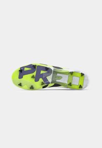 Bright yellow and black soccer cleat sole with triangular studs and the word "PREDATOR" printed underneath.