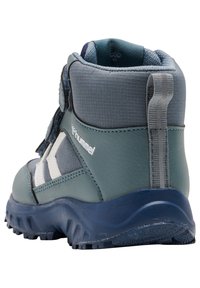 Grüne und blaue Kinderwanderstiefel mit strukturierter Oberfläche, knöchelhoch und weißen Akzenten, ausgestattet mit einem Zugverschluss und einer robusten Sohle.