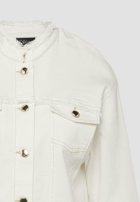Elfenbeinfarbige Jeansjacke mit ausgefranstem Kragen, goldfarbenen Knöpfen und einer einzelnen mit Knopf verschlossenen Brusttasche auf der rechten Seite.