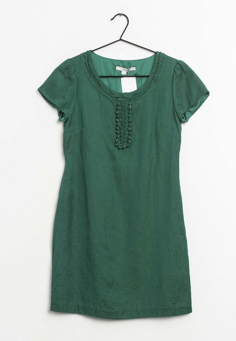 Green short-sleeve dress with a scoop neck, featuring textured detailing and fabric ruffles down the center. Smooth, lightweight material.