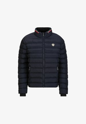 Marinekleurige pufferjack met een hoge kraag, een ritssluiting aan de voorkant en ribgebreide manchetten. Heeft een klein logo en een accent van rood, groen en wit gestreept.
