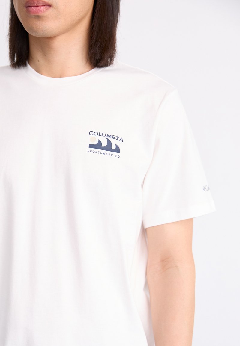 Biała bawełniana koszulka z niebieskim nadrukowanym logo na lewej piersi oraz małym akcentem na rękawie. Krótkie rękawy, okrągły dekolt.