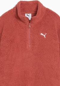 Pullover in pile rosso corallo, con design a mezza zip, colletto alto, superficie texturizzata e dettaglio del logo bianco sul petto.