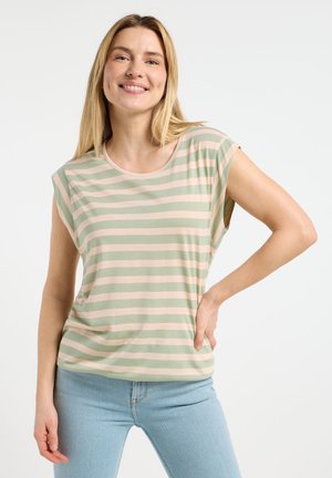 T-shirt leggera a righe in verde chiaro e rosa pallido, con scollatura rotonda e maniche corte, abbinata a jeans blu aderenti.