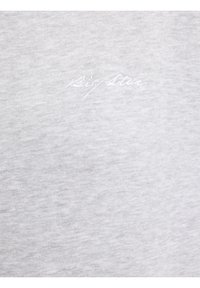 Svijetlosivi tkanina s diskretnim bijelim vezenim tekstom pisanom kurzivom, na kojem piše "Big Star" blizu centra.