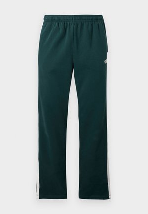 Dunkelgrüne Sweatpants mit elastischem Bund und weißen Streifen, die an den äußeren Seiten der Beine entlanglaufen.