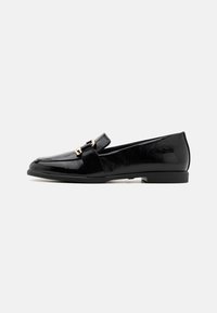 Black patent leather loafers with a flat heel, featuring a prominent strap and gold-tone hardware, smooth texture, and classic design.