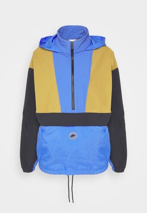 Jachetă vântoasă colorată cu panouri albastre, galbene și negre. Prezintă un guler cu fermoar, șnur ajustabil la tiv și un patch cu logo pe față.
