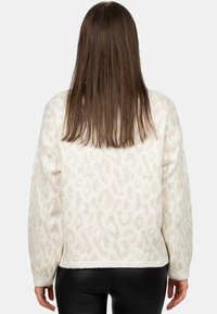 Maglione bianco fluffy con stampa leopardata beige chiaro, spalle scese e polsini a costine. Tessuto liscio con vestibilità rilassata.