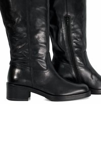 Bottes noires en cuir, montant jusqu'au genou, avec une texture lisse, un bout carré et un petit talon empilé ; équipées d'une fermeture éclair sur le côté.